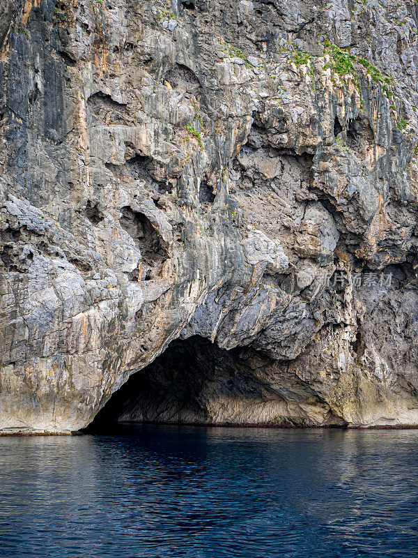 Cova de Ses Tres Maries海洞入口，位于马略卡岛崎岖的悬崖内，只能通过海路到达，以前是走私者的藏身之处，现在吸引着冒险的皮划艇旅行，是难忘假期的理想选择。